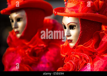 Rouge vif et costumes à froufrous ornent deux femmes à st. la place Saint-Marc à Venise pendant le carnaval. Banque D'Images