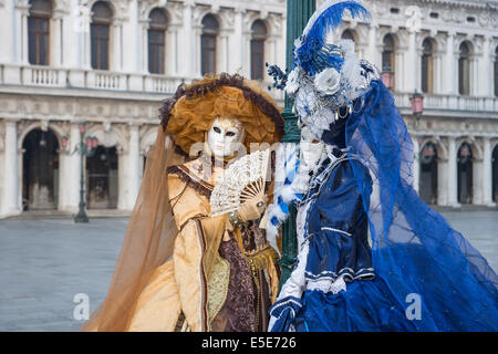 Or et bleu en costume Renaissance mesdames dans la place Saint Marc à Venise pendant le carnaval. Banque D'Images