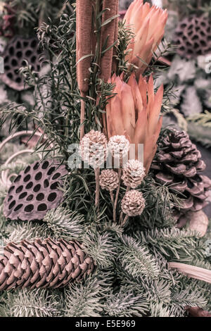 Arrangement de fleurs automnales décorative avec les cônes brindilles d'épinette et dans les oranges et vertes, vertical de l'image. Banque D'Images