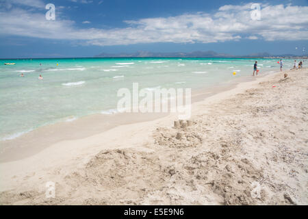 Vaste plage de sable fin, l'émeraude de l'eau claire comme du cristal et les enfants jouant dans la distance. Playa de Muro, Majorque, îles Baléares, Espagne. Banque D'Images