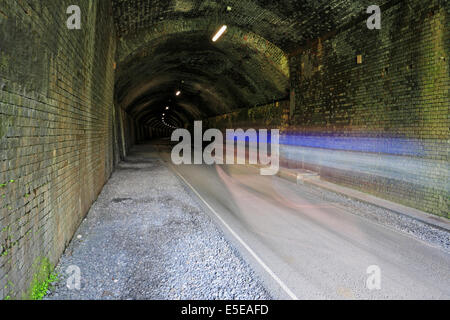 Les cyclistes de flou dans Litton Tunnel sur le sentier, Derbyshire Monsal, Peak District National Park, Angleterre, Royaume-Uni. Banque D'Images