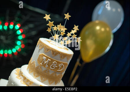 Haut niveau d'une célébration noces d'or gâteau avec lettres m & d pour maman et papa, deux ballons et le sucre stars Banque D'Images