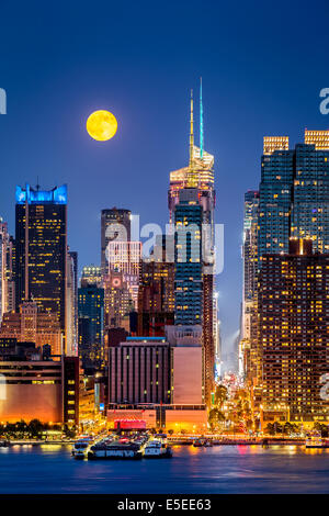 Super pleine Lune s'élever au-dessus des gratte-ciels de midtown Manhattan Banque D'Images