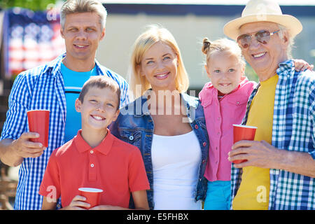 Portrait of senior man et jeune couple avec leurs enfants à la caméra à l'extérieur Banque D'Images