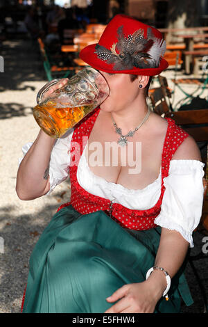 Femme en costume bavarois typique boit de la bière dans un jardin de bière Banque D'Images