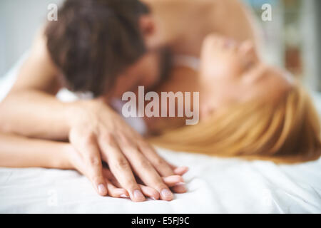 Mains de femmes et d'hommes lying on bed Banque D'Images