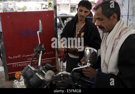 Sanaa, Yémen. 30 juillet, 2014. Les yéménites remplir leurs motos avec de l'essence à une station service à Sanaa, Yémen, le 30 juillet 2014. Le gouvernement yéménite a augmenté le prix de l'essence à partir de 125 rials yéménites (0,58 dollar américain) à 200 rials par litre et de disel 100 rials à 195 rials le mercredi, ce qui a suscité des protestations de masse dans la capitale Sanaa. Des manifestants en colère ont brûlé des pneus et coupé de nombreuses routes dans la région de Sanaa. Le gouvernement a déployé plus de soldats pour maintenir la sécurité dans la capitale. Credit : Mohammed Mohammed/Xinhua/Alamy Live News Banque D'Images