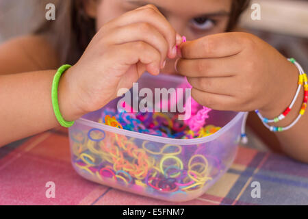 La création de décisions fille coloré bracelet 'loom bands mains artisanat gros plan portrait Banque D'Images