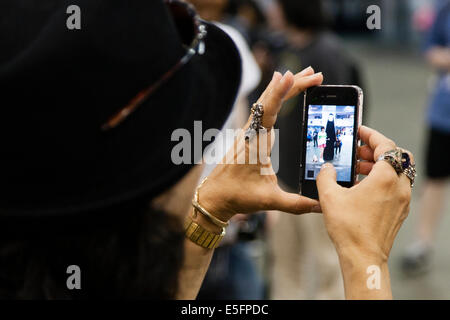 Londres, Angleterre Une femme prend une photo d'une paire de cosplayeurs au Japon Hyper dans Earl's Court. Banque D'Images