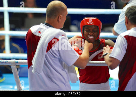 Glasgow, Ecosse, Royaume-Uni. 30 juillet, 2014. Nicola Adams (FRA) avoir sa tête guard supprimé après son combat avec Erandi De Silva (SRI) chez les femmes de la demi-finale de la masselotte à la XX Jeux du Commonwealth, Glasgow. Adams a gagné avec un score de 120 points à 100. Sa bouche garde côtière indique 'Babyface'. Crédit : Michael Preston/Alamy Live News Banque D'Images