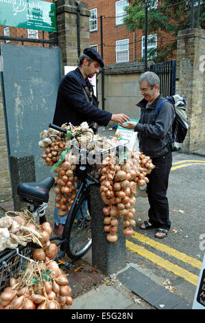 Vendeur l'oignon - l'homme de vendre les oignons et l'ail à partir de la location à l'extérieur d'Islington Farmers Market London England UK Banque D'Images