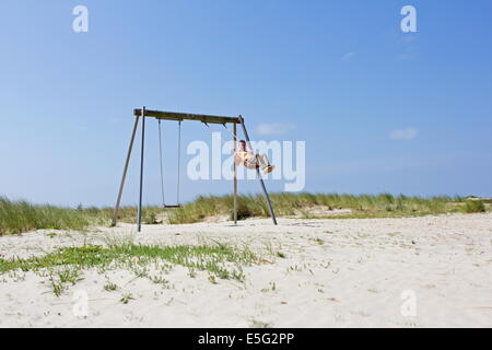 Borkum, Allemagne : 29 juillet 2014 - Dame rocking sur l'aire de jeux Banque D'Images