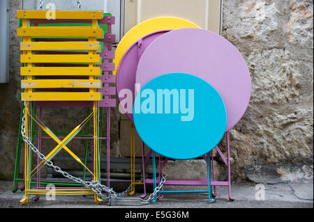 Tables de café couleur verrouillés ensemble avec une chaîne dans une ruelle. Banque D'Images