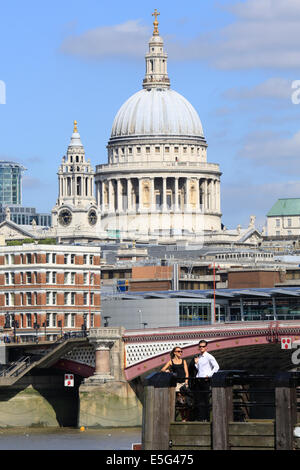 Un jeune couple debout sur un quai de la rive sud en face de la Tamise et de la cathédrale St Paul, London, UK Banque D'Images