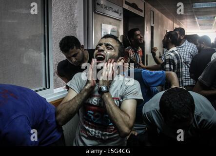 La ville de Gaza, la bande de Gaza. 30 juillet, 2014. Les hommes palestiniens se sont couchés sur le sol en attendant de recevoir le traitement, blessés par une frappe israélienne dans le quartier de Shijaiyah, à l'urgence de l'hôpital Shifa. Credit : Ezz Al-Zanoun Images/APA/ZUMA/Alamy Fil Live News Banque D'Images