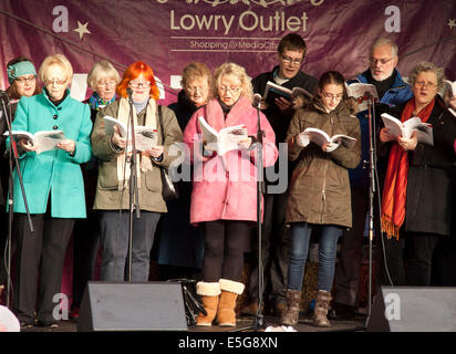 Chant choral à l'époque victorienne au marché le Lowry Centre à Noël. Banque D'Images