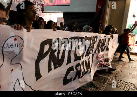 Sao Paulo, Brésil. 30 juillet, 2014. Les protestataires mars avec un drapeau qui indique, 'protestant n'est pas un crime" au cours d'une protestation contre l'emprisonnement de militants par la police et contre la loi pénale de mouvements sociaux dans le centre de Sao Paulo, Brésil. Credit : Tiago Mazza Chiaravalloti/Pacific Press/Alamy Live News Banque D'Images