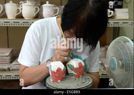 (140731) -- Road, le 31 juillet 2014 (Xinhua) -- une femme apprend la technique céramique Yingge dans Street de Road Ville, sud-est de la Chine, Taiwan, le 30 juillet 2014. L'histoire de la production de céramique à Yingge Street a commencé il y a environ 200 ans, différentes sortes de céramiques fines produites ici attirent de nombreux touristes. (Xinhua/Il Junchang) (WHW) Banque D'Images