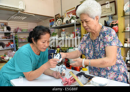 (140731) -- Road, le 31 juillet 2014 (Xinhua) -- une femme (L) apprend la peinture en céramique d'un professeur dans la rue de Yingge Road Ville, sud-est de la Chine, Taiwan, le 30 juillet 2014. L'histoire de la production de céramique à Yingge Street a commencé il y a environ 200 ans, différentes sortes de céramiques fines produites ici attirent de nombreux touristes. (Xinhua/Il Junchang) (WHW) Banque D'Images