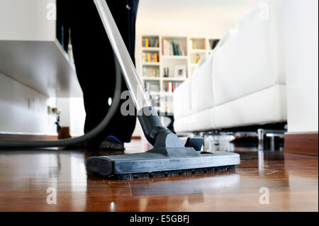 Femme qui nettoie le plancher de la chambre Banque D'Images