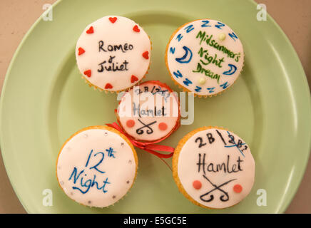 Cup cakes sur une plaque avec les titres de certaines pièces de Shakespeare dans des écrits à une foire d'été, râteau, Hampshire, Royaume-Uni. Banque D'Images