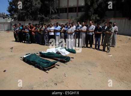 La bande de Gaza. 31 juillet, 2014. Gaza, lors d'une attaque aérienne israélienne dans Al-Shejaiya marché quartier. 31 juillet, 2014. Pleureuses palestinienne prier sur le corps de al-famille de soie, qui a déclaré que les infirmiers ont été tués dans une frappe aérienne israélienne à un marché en Al-Shejaiya quartier, au cours de leurs funérailles à Gaza le 31 juillet 2014. Autour de 17 obus d'artillerie israéliens ont frappé sur le marché Mercredi, tuant 17 Palestiniens et blessé plus de 170 personnes, médecins et selon des témoins. Credit : Yasser Qudih/Xinhua/Alamy Live News Banque D'Images