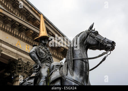 Glasgow, Ecosse, Royaume-Uni. 31 juillet, 2014. Dans la célébration de la réussite des Jeux du Commonwealth, le régulier et emblématiques du cône de circulation rouge et blanc sur la tête de la statue du duc de Wellington (normalement il n'y comme une farce d'étudiants) a été remplacé par l'un de l'or peint. La statue, avec un cône de circulation sur le dessus, à l'extérieur de la galerie d'Art Moderne de Royal Exchange Square a été utilisé comme un exemple de l'humour et de Glasgow est un intérêt continu pour les touristes et habitants de la région. Credit : Findlay/Alamy Live News Banque D'Images