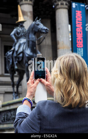 Glasgow, Ecosse, Royaume-Uni. 31 juillet, 2014. Dans la célébration de la réussite des Jeux du Commonwealth, le régulier et emblématiques du cône de circulation rouge et blanc sur la tête de la statue du duc de Wellington (normalement il n'y comme une farce d'étudiants) a été remplacé par l'un de l'or peint. La statue, avec un cône de circulation sur le dessus, à l'extérieur de la galerie d'Art Moderne de Royal Exchange Square a été utilisé comme un exemple de l'humour et de Glasgow est un intérêt continu pour les touristes et habitants de la région. Credit : Findlay/Alamy Live News Banque D'Images
