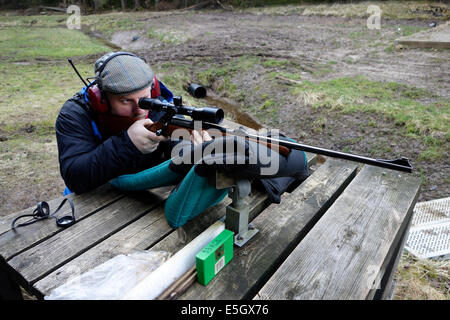 Hunter avec fusil de chasse équipé d'un champ d'application est sur le point de tourner un cycle de formation. Banque D'Images