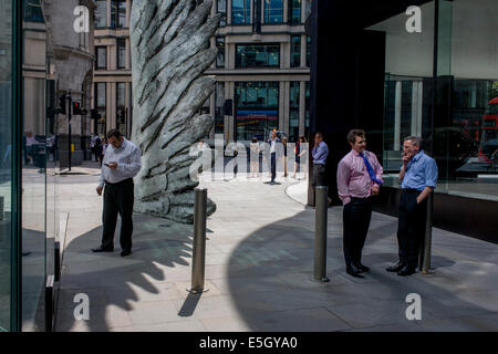 Les travailleurs de la ville de fumer des cigarettes par le géant de l'oeuvre une aile de bronze lors d'un midi de printemps dans le quartier financier de Londres. Comme la lumière se reflète sur les immeubles de bureaux à proximité, la foule à l'heure du déjeuner devant ce géant des illustrations sur leur façon de réunions et sandwicheries. Les dix mètres de haut est la sculpture en bronze par le président de la Royal Academy of Arts, Christopher Le Brun, commandé par Hammerson en 2009. Elle est appelée 'La Ville' de l'aile et a été jeté par Morris Singer, fondateurs de l'art réputé pour être la plus ancienne fonderie d'art dans le monde. Banque D'Images