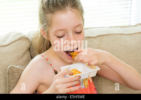 Jeune fille manger des biscuits comme casse-croûte Banque D'Images