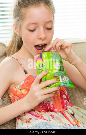 Young Girl eating sachet de bonbons / confiserie Banque D'Images