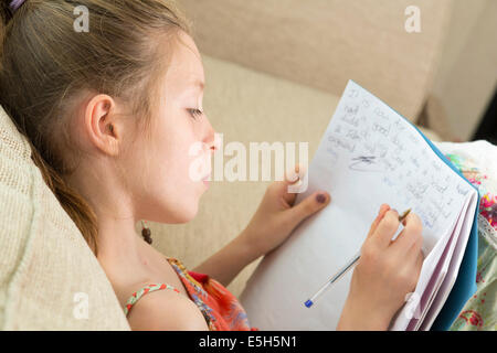 Jeune fille écrit essai / faire des devoirs / dans journal Banque D'Images