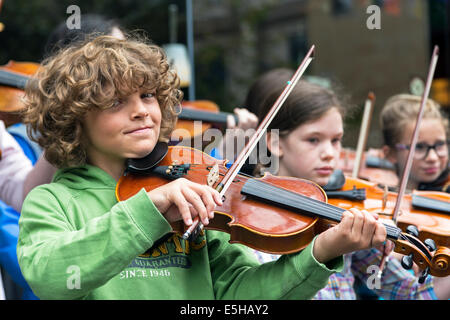 Robby Whyte, âgé de 11 ans, un élève de l'école gaélique Glasgow, Glasgow, aux spectacles de rue avec un certain nombre d'autres élèves Banque D'Images
