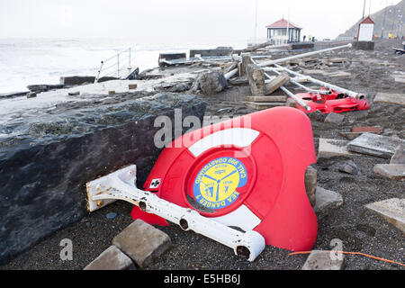 Aberystwyth, Pays de Galles, Royaume-Uni. 03 janvier 2014. 10-AVANT : PROMENADE ET RAMPES DE BORD PENDANT LA TEMPÊTE. Le nettoyage après la pire tempête à frapper de mémoire d'Aberystwyth. De grandes parties de la promenade de bord de mer et les garde-corps ont été arrachés lors de la tempête féroce ce matin. Les autorités locales estiment que le coût de la clarifier et de réparation, d'exécuter dans plusieurs centaines de milliers d'euros. Un 5.3m high springtide et force de coup de vent d'ouest du sud porté contre le martèlement tisse massive promenade et le port à Aberystwyth, sur la côte ouest du pays de Galles. Credit : Keith morris/Alamy Liv Banque D'Images