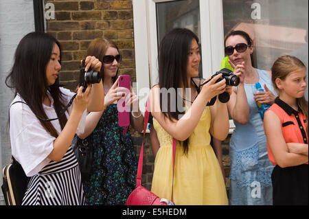 Les visiteurs à l'aide de caméras numériques et les smartphones pour photographier Oyster Festival parade à Whitstable Kent England UK Banque D'Images