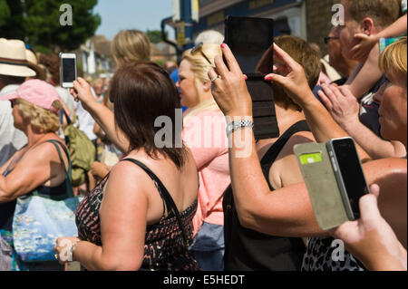 Les personnes utilisant l'ordinateur tablette numérique & smartphones que des caméras pour photographier Oyster Festival parade à Whitstable Kent England UK Banque D'Images