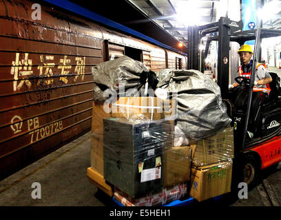 (140801) -- SHANGHAI, le 1 août 2014 (Xinhua) -- un travailleur charge un train de marchandises de la navette avec des marchandises à la gare de fret Minhang Shanghai, la Chine orientale, le 1 août, 2014. Shanghai a lancé son premier e-commerce le train navette le vendredi. Le train passe entre Pékin et Shanghai, en réduisant les temps de voyage à partir de l'intervalle de cinq jours à 18 heures. (Xinhua/Chen Fei) (HDT) Banque D'Images