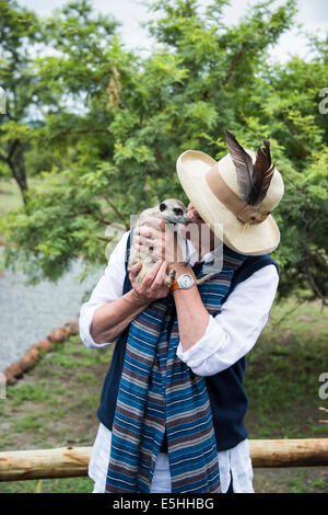 Méconnaissable woman kissing meerkat (Suricata suricatta) Nambiti Réserver, Kwa-Zulu Natal, Afrique du Sud Banque D'Images