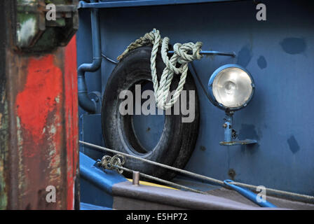 Détail d'un vieux bateau avec une corde, ceinture de sécurité et lampe, fixés sur bollard Banque D'Images