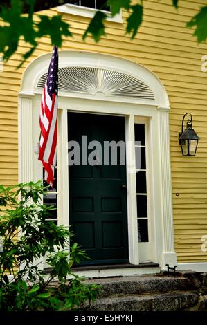 Hancock, NH : une porte sur l'ère coloniale une baraque en bois du 18ème siècle avec un entraîneur d'une lanterne et drapeau Américain Banque D'Images