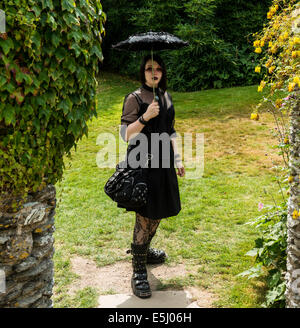 Le 30 juillet 2014. Kingswear, Devon, Angleterre. Une jeune femme vêtue comme une Goth pose pour la caméra à une maison de campagne dans le Devon. Banque D'Images