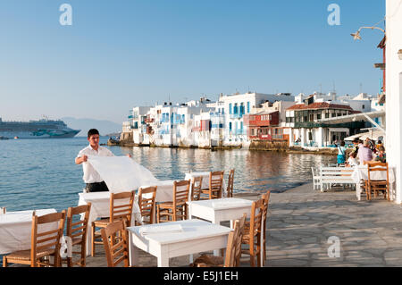 Garçon portant à des tables, le restaurant en front de mer dans la zone de la petite Venise de Mykonos, Grèce Banque D'Images