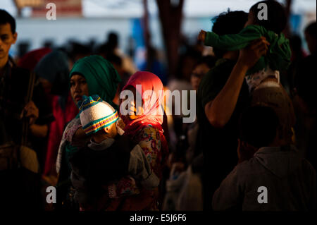 Jakarta, Indonésie. 2e août, 2014. Une femme tenant un enfant est de Senen gare à Jakarta, Indonésie, le 2 août 2014. Après l'Aïd al-Fitr en célébration d'origine, des milliers de personnes Retour à Jakarta pour travailler. © Sanovri Veri/Xinhua/Alamy Live News Banque D'Images