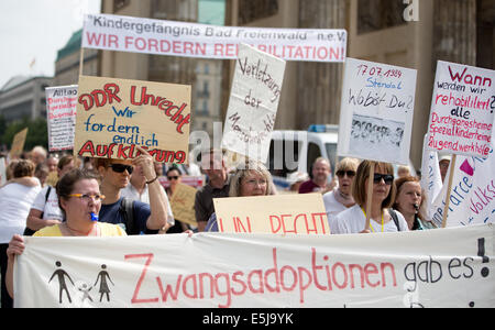 Berlin, Allemagne. 07 août, 2014. Les participants à une manifestation sur le thème "Les victimes oubliées de la réévaluation de la demande régime' protester contre la porte de Brandebourg à Berlin, Allemagne, 02 août 2014. L'organisation est l'organisation 'Hilfe für die Opfer von Zwangsadoptionen-DDR' (l'aide aux victimes de l'adoption forcée de la RDA) en coopération avec l'union des associations de victimes contre la tyrannie communiste. Photo : JOERG CARSTENSEN/dpa/Alamy Live News Banque D'Images