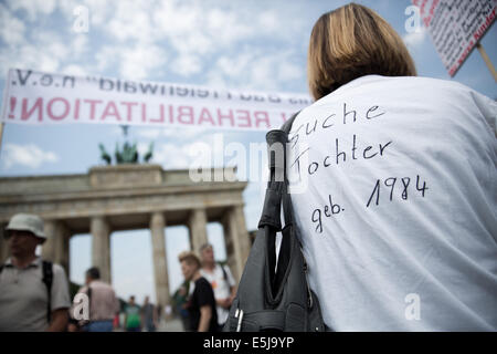 Berlin, Allemagne. 07 août, 2014. Les participants à une manifestation sur le thème "Les victimes oubliées de la réévaluation de la demande régime' protester contre la porte de Brandebourg à Berlin, Allemagne, 02 août 2014. L'organisation est l'organisation 'Hilfe für die Opfer von Zwangsadoptionen-DDR' (l'aide aux victimes de l'adoption forcée de la RDA) en coopération avec l'union des associations de victimes contre la tyrannie communiste. Photo : JOERG CARSTENSEN/dpa/Alamy Live News Banque D'Images