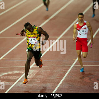 Glasgow Hampden Park 2 août 2014. Jeux du Commonwealth Men's 4x100 final. Usain Bolt met la baguette pour la Jamaïque en un temps record de nouveaux jeux 37,58. L'Angleterre a terminé deuxième en 38,02. L'équipe jamaïcaine - Jason Livermore ; Kemar Bailey-Cole ; Nickel Ashmeade et Usain Bolt. Danny Talbot FRA suit derrière en deuxième Banque D'Images