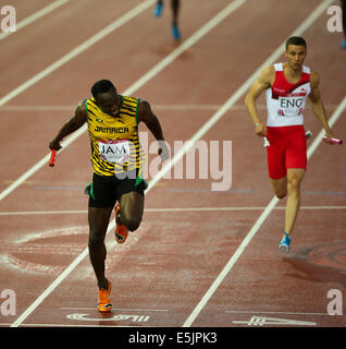 Glasgow Hampden Park 2 août 2014. Jeux du Commonwealth Men's 4x100 final. Usain Bolt met la baguette pour la Jamaïque en un temps record de nouveaux jeux 37,58. L'Angleterre a terminé deuxième en 38,02. L'équipe jamaïcaine - Jason Livermore ; Kemar Bailey-Cole ; Nickel Ashmeade et Usain Bolt. Danny Talbot FRA suit derrière en deuxième Banque D'Images