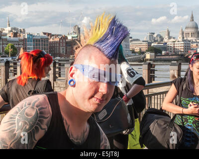 Mode de vie moderne : un jeune homme avec des tatouages, piercings lèvre et un gel de couleur punk Mohican hairstyle et lunettes cool blue, South Bank, Londres Banque D'Images