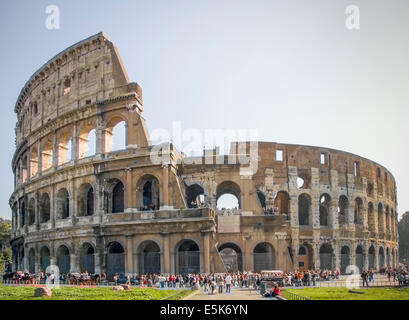 La foule et les touristes profitant du soleil au Colisée, l'ancien amphithéâtre romain dans le coeur de Rome, Latium, Italie Banque D'Images